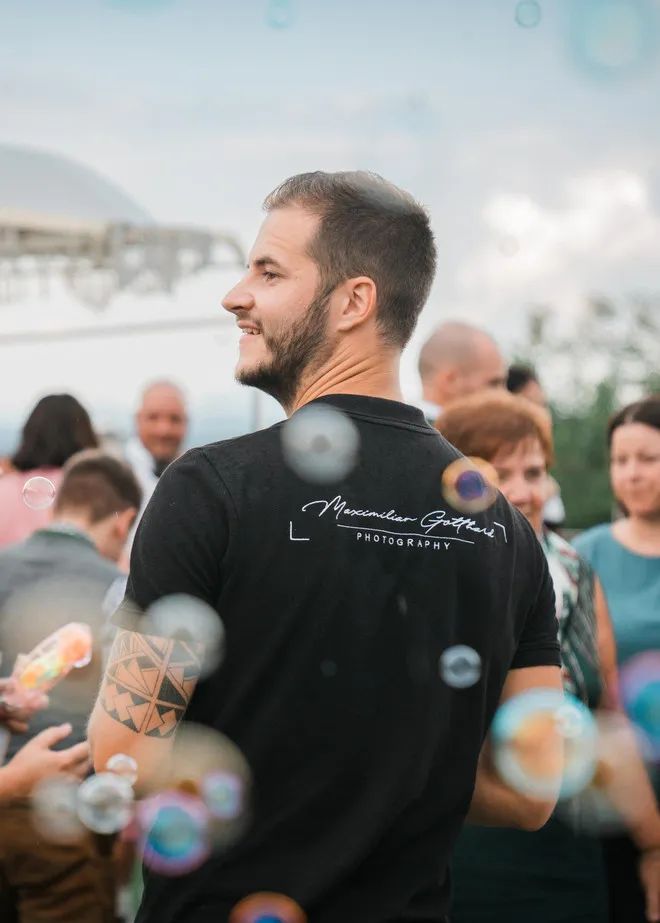 Maximilian Gotthard mit Kamera bei einer Hochzeit, umgeben von Seifenblasen